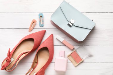 Hafif ahşap arka planda kadın aksesuarları ve kozmetik ürünleri.