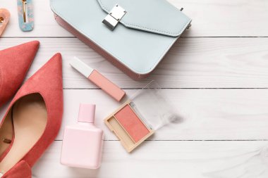 Hafif ahşap arka planda kadın aksesuarları ve kozmetik ürünleri.