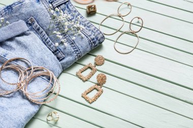 Kadın aksesuarları ve kıyafetleri renkli ahşap arka planda.