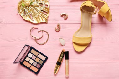 Ahşap renkli arka planda kadın aksesuarları ve kozmetik ürünleri