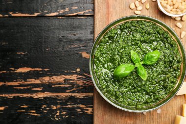 İçinde taze pesto sosu ve koyu ahşap masa malzemeleri olan bir pansiyon.