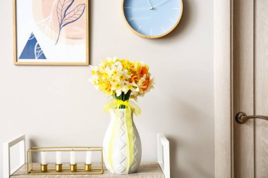 Çok güzel narsist çiçekleri ve mumları olan bir vazo.