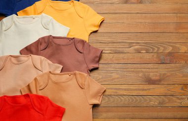 Tahta arka planda bebek kıyafetleri, yakın plan.