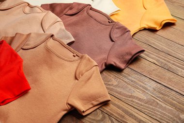 Tahta arka planda bebek kıyafetleri, yakın plan.