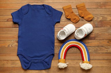 Ahşap arka planda bebek kıyafetleri.