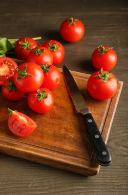 Ahşap zemin üzerinde taze olgun domateslerle dolu bir tahta.