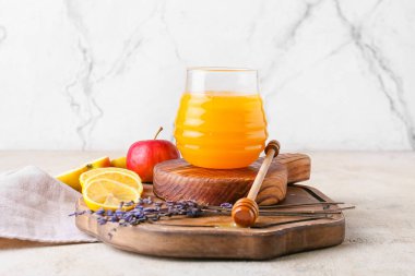 Tahta kaplamalı tahtalar, bal kavanozu ve hafif arka planda meyveler.