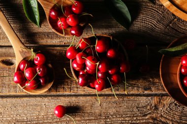 Ahşap zemin üzerinde olgun kirazlı kompozisyon