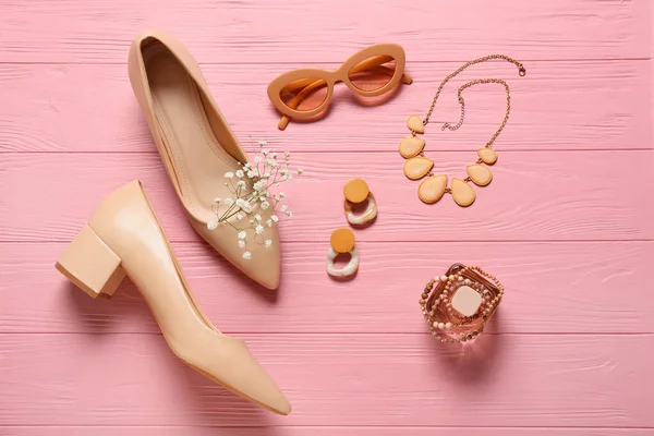 カラー木製の背景にスタイリッシュな靴を持つ女性のアクセサリーのセット — ストック写真