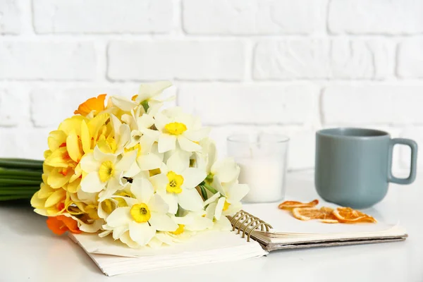 Όμορφα Λουλούδια Νάρκισσος Σημειωματάριο Και Κύπελλο Στο Τραπέζι Στο Δωμάτιο — Φωτογραφία Αρχείου