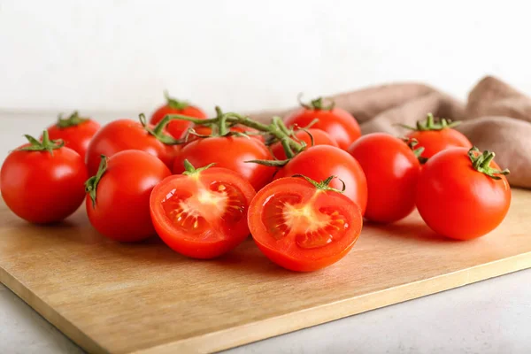 Deska Świeżymi Dojrzałymi Pomidorami Jasnym Tle Zbliżenie — Zdjęcie stockowe