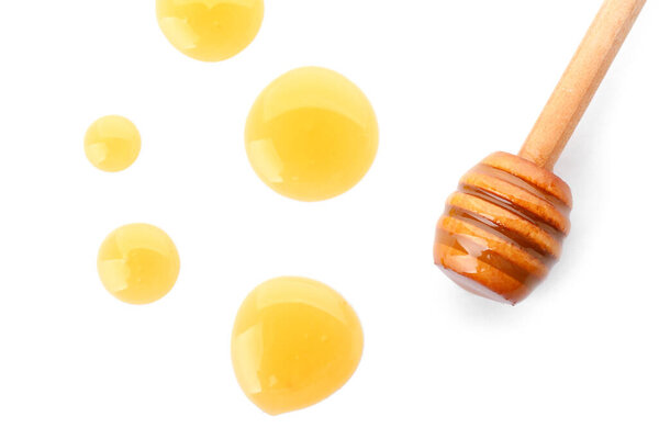 Wooden dipper with honey on white background