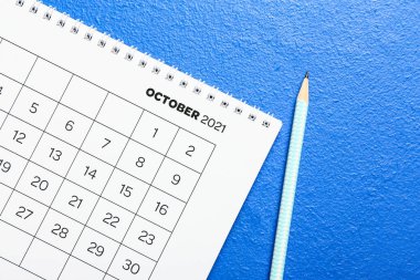 Kağıt takvimi ve kalemi renk arkaplanı üzerine çevir, kapat