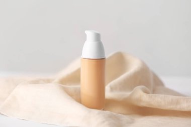 Hafif arkaplanda bir şişe makyaj malzemesi