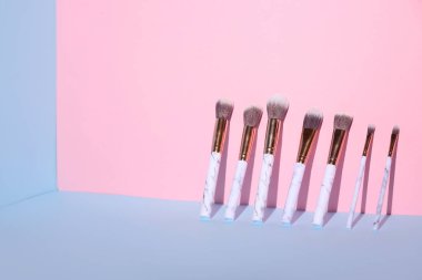 Renk arkaplanındaki makyaj fırçaları