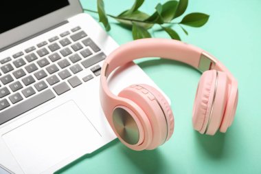 Renkli arka planda modern kulaklıklar ve dizüstü bilgisayarlar, yakın plan