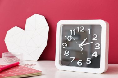 Renk duvarının yanındaki masa üzerindeki saat ve dekor şık