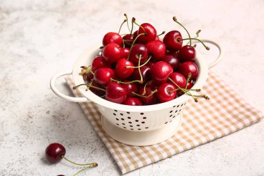 Hafif arka planda lezzetli olgun kirazlı Colander