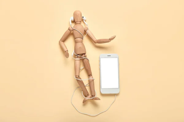 Mannequin with modern earphones and mobile phone on color background