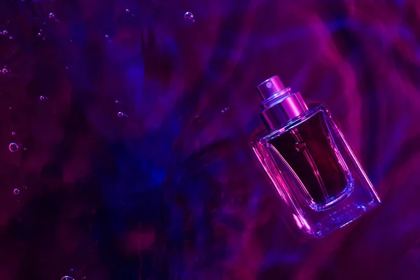 Бутылка Духов Воде Цветном Фоне — стоковое фото