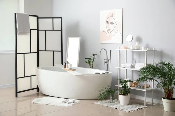 Interior of stylish bathroom with folding screen