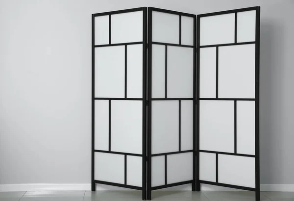 Modern folding screen near light wall