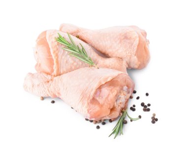 Beyaz arka planda çiğ tavuk bacağı ve baharatlar.