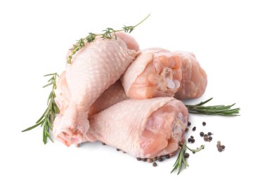 Beyaz arka planda çiğ tavuk bacağı ve baharatlar.