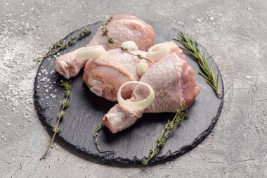 Gri arka planda çiğ tavuk bacaklı tahta