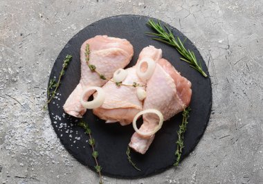 Gri arka planda çiğ tavuk bacaklı tahta