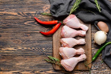 Ahşap arka planda çiğ tavuk bacağı olan tahta.