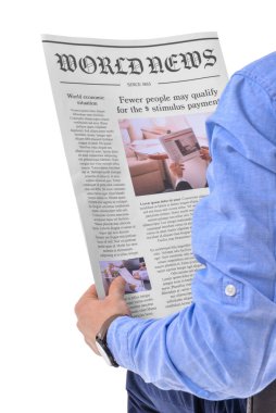 Genç adam beyaz arka planda gazete okuyor.