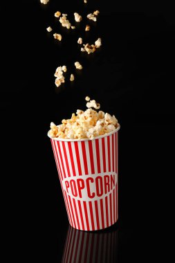 Koyu arkaplanda lezzetli patlamış mısır kovası