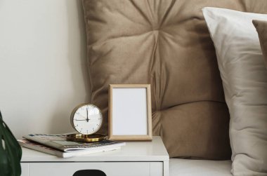 Yatağın yanındaki masada şarjörlü çalar saat.