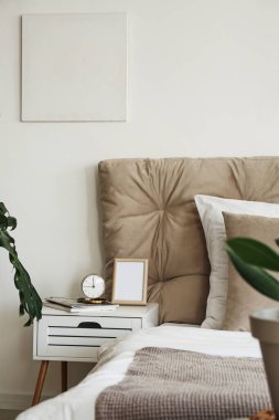 Çalar saati olan şık bir yatak odası.