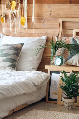 Çalar saati olan şık bir yatak odası.