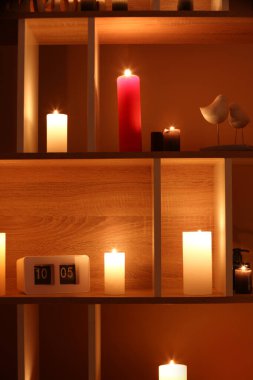 Odadaki kitaplıkta mum ve saat yakmak.