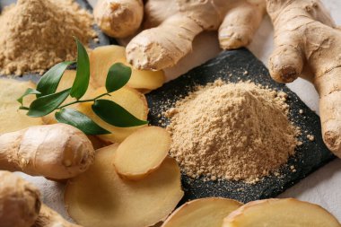 Hafif arkaplanda zencefil tozu ve kökleri yığını