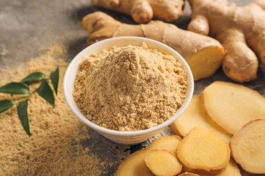 Grunge arka planında zencefil tozu olan kase, yakın plan.