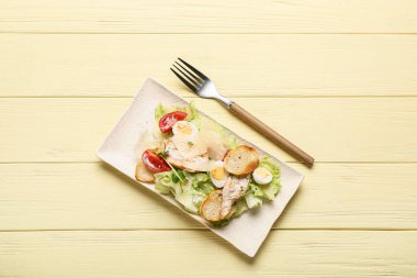 Renkli ahşap arka planda lezzetli Sezar salatası.