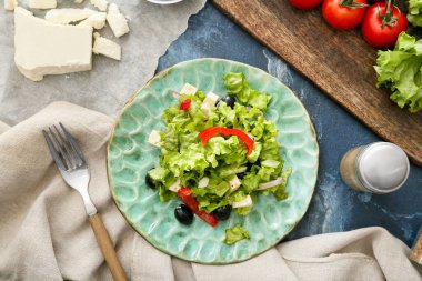 Taze Yunan salatası ve arka planda bulunan malzemelerle dolu tabak.