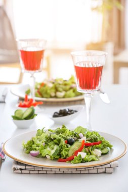 Restorandaki masada taze Yunan salatası ve bir bardak şarap.