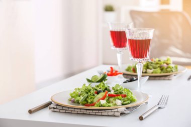Restorandaki masada taze Yunan salatası ve bir bardak şarap.