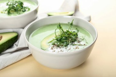 Arka planda yeşil gazpacho ve avokado olan kaseler