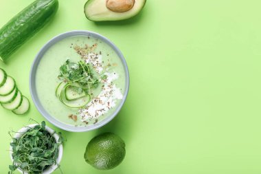 Yeşil gazpacho ve renk arkaplan içerikli bir kase.