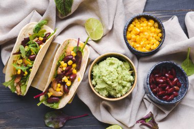 Takolu kompozisyon ve koyu ahşap arka planda lezzetli guacamole.