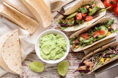 Takolu kompozisyon ve hafif ahşap arka planda kâsede lezzetli guacamole.