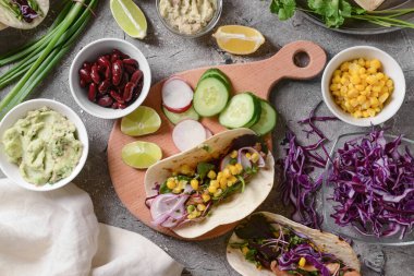 Taco, malzeme ve arkaplanda lezzetli guacamole karışımı.