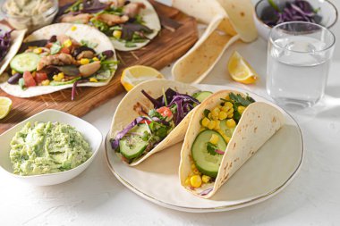 Taco tabağı, kasede lezzetli guacamole ve arka planda bir bardak su.