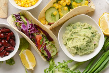 Taco ve lezzetli guacamole tabakta, arka planda, yakın plan.